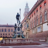 Bologna - Fontana di Nettuno or Neptune fountain on Piazza Maggiore square and Palazzo Comunale in fogy morning