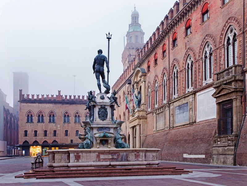 Bologna - Fontana di Nettuno or Neptune fountain on Piazza Maggiore square and Palazzo Comunale in fogy morning